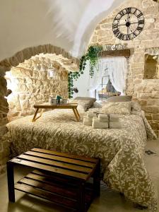 1 dormitorio con 1 cama grande y reloj en la pared en Domus Klara, en Turi