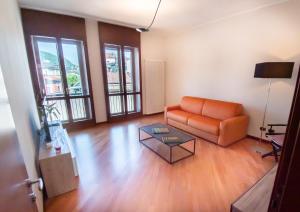 een woonkamer met een oranje bank en een tafel bij SIUM'S APARTMENT in Como