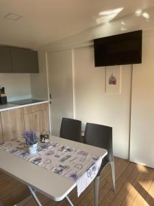 une cuisine avec une table, des chaises et une nappe dans l'établissement Mobile Homes Dololego - Camp Baško Polje, à Baška Voda