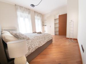 een slaapkamer met een bed en een lamp op een houten vloer bij SIUM'S APARTMENT in Como