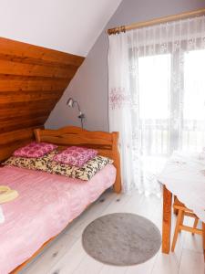 a bedroom with two beds and a large window at Willa Rycerz in Niedzica Zamek