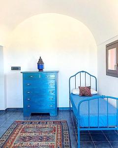 a bedroom with a blue dresser and a blue bed at dammuso dehors in Pantelleria