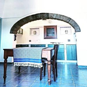 a table in a kitchen with an archway at dammuso dehors in Pantelleria