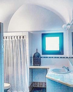 a bathroom with a sink and a toilet and a window at dammuso dehors in Pantelleria