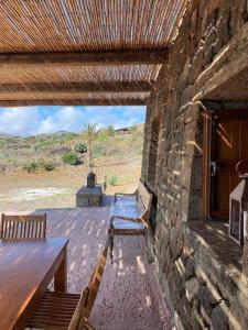 a patio with two benches and a stone wall at dammuso dehors in Pantelleria