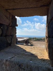 a stone building with a view of the ocean at dammuso dehors in Pantelleria