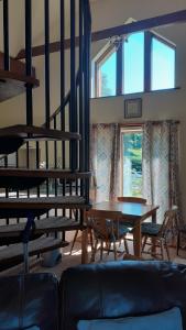 sala de estar con mesa y sillas y escalera en Tarnside Cottages, en Brampton