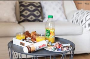 a table with a plate of food and a bottle of drink at Superbe studio apartment à 2MN de Paris in Gentilly