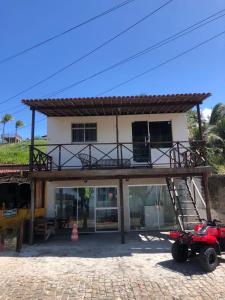 una casa con balcón en la parte superior en Verano House BF, en Baía Formosa