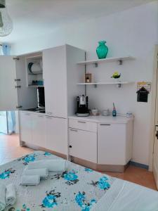 eine Küche mit weißen Schränken und blauen Blumen auf dem Boden in der Unterkunft I 23 PASSI GAETA in Gaeta