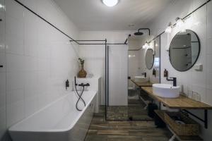 a bathroom with two sinks and two mirrors at Hustadvika Havhotell - by Classic Norway Hotels in Farstad