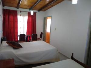 um quarto com 2 camas, uma mesa e cadeiras em Departamentos PAEZ em Malargüe