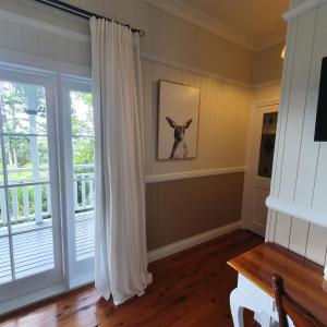 Mount Glorious的住宿－Maiala Park Lodge，一间房间,墙上挂着一幅狗的照片,窗户上有一个窗口