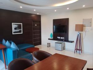 un soggiorno con divano blu e TV di The Bull Boutique Hotel a Pondicherry