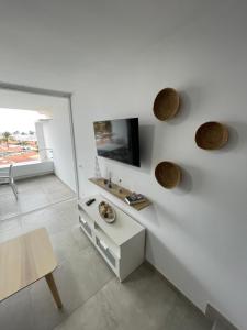 Biały salon ze stołem i telewizorem w obiekcie Apartamento JOSE w mieście San Bartolomé