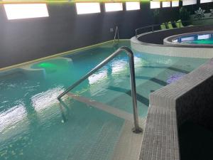 a swimming pool with a large tub next to it at Apartahotel & Spa Jacetania in Jaca