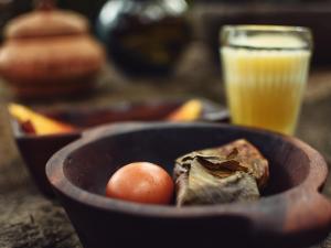 a bowl of food with a egg and a glass of orange juice at Gocta Miradors Deluxe in Cocachimba