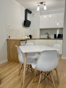 シュチェチンにあるApartment Insat IVのキッチン(白いテーブル、白い椅子付)