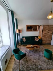 a living room with a green couch and chairs at design loft morska 7 in Puck
