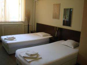 two beds in a hotel room with towels on them at Guest House Lazur in Burgas