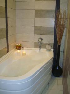 a bathroom with a tub with candles in it at Guest House Lazur in Burgas +30 photos