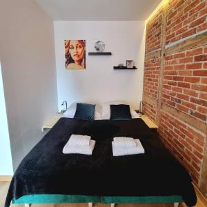 a bedroom with a bed with a brick wall at design loft morska 7 in Puck