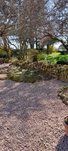 un jardín con una pared de piedra y flores en propriété familiale MERLE proche PARAY LE MONIAL en Vauban