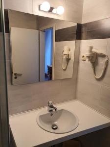 uma casa de banho com um lavatório e um espelho em Hotel Friedensbruecke em Greiz