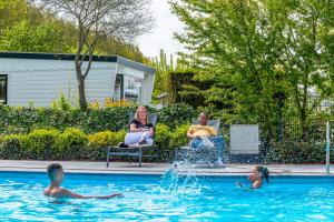 un grupo de personas sentadas en sillas en una piscina en EuroParcs Molengroet, en Noord-Scharwoude