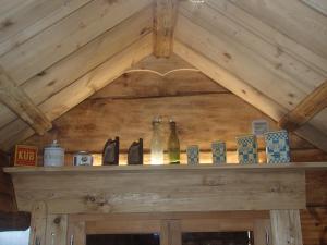a wooden shelf with bottles on top of a fireplace at Le Grenier in Saint-Paul-en-Chablais