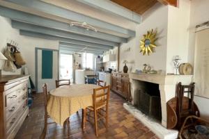 uma cozinha com uma mesa e uma lareira em House Rétaise With Garden Close To The Sea em La Couarde-sur-Mer