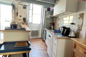 uma cozinha com armários brancos e uma bancada em House Rétaise With Garden Close To The Sea em La Couarde-sur-Mer