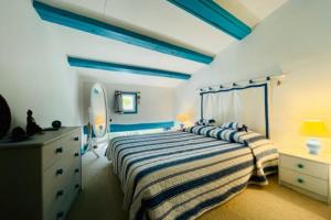 um quarto com uma cama azul e branca e uma cómoda em House Rétaise With Garden Close To The Sea em La Couarde-sur-Mer