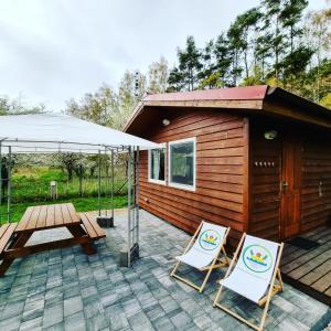 eine Terrasse mit 2 Stühlen, einem Tisch und einem Zelt in der Unterkunft Wakacje na Wyspie in Danzig