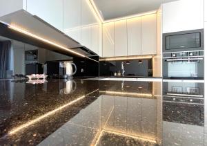 uma cozinha com um balcão preto e branco em Made for You AMC apartament przy AquaParku em Rumia