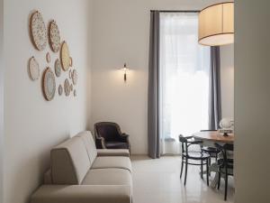 - un salon avec un canapé et une table dans l'établissement Living u HomeSuites, à Lecce