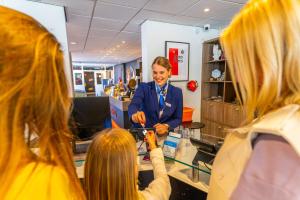 a woman is taking a picture of two girls at EuroParcs Beekbergen in Beekbergen