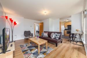 uma sala de estar com um sofá e uma mesa em Suites by Rehoboth - Palmers Green - London em Londres