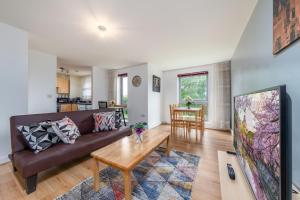 a living room with a couch and a table at Suites by Rehoboth - Palmers Green - London in London