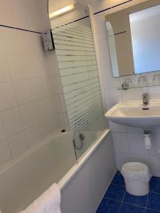a bathroom with a sink, toilet and bathtub at SHELDER Hôtel - CHERBOURG EN COTENTIN - Equeurdreville in Cherbourg en Cotentin