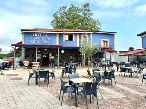 un groupe de tables et de chaises devant un restaurant dans l'établissement Hotel Villa Maria, à Revilla de Camargo