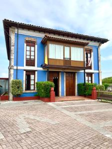 a blue and white house with a bench in front of it at Hotel Villa Maria in Revilla de Camargo