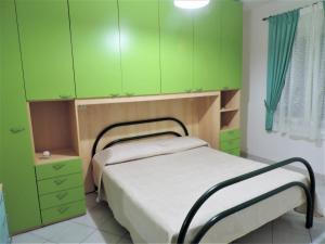 a bedroom with green cabinets and a bed in it at Residenza Su Portu in Orosei
