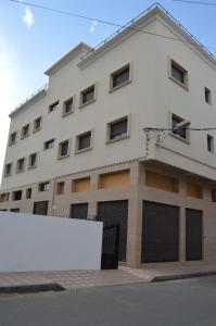 a building with a white sign in front of it at Suites Appartement Midelt in Midelt