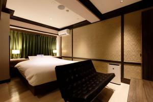 Habitación de hotel con cama y silla en HOTEL555 沼津駅北, en Numazu