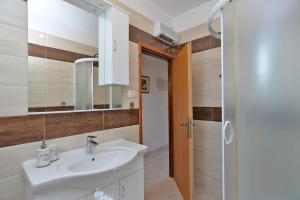 ein Badezimmer mit Waschbecken und Spiegel in der Unterkunft Apartments Mira 615 in Rovinj