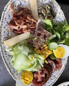 a plate with a salad with bacon cheese and vegetables at EVASION DE LOIRE in Jargeau +38 photos