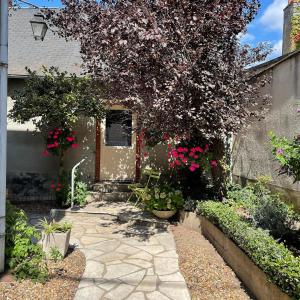 una casa con un camino de piedra que conduce a una puerta con flores en EVASION DE LOIRE, en Jargeau