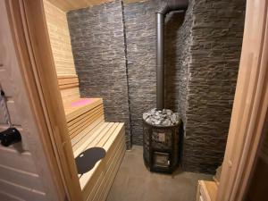 a sauna with a stone wall and a stove at Irbosk Apartments in Kiviõli