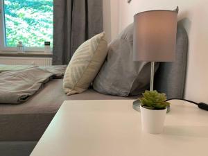 une lampe sur une table à côté d'un lit dans l'établissement Central Apartment Flensburg, à Flensbourg